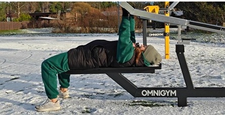 henkilö ulkokuntosalilla penkkipunnertamassa